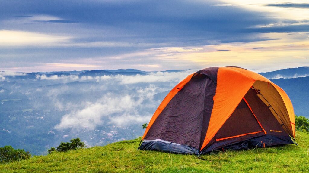 tente orange planté en haut d'une montagne